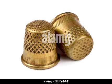 Two antique copper thimbles on a white background. Old thimbles close-up. A selective focus. Stock Photo