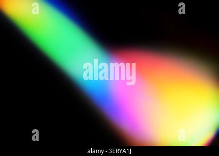 Colorful spectrum beam with glowing edges on dark backdrop. Abstract lens flare effect ideal for photo overlays and creative editing. Stock Photo