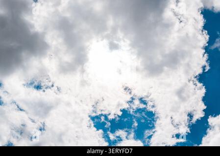 Ethereal light of the sun behind dramatic stormy cloud formations. Dramatic sun breaking through dark, heavy storm clouds. Stock Photo