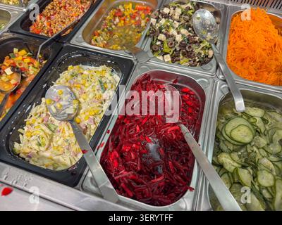 Assorted fresh salads from a salad bar with beetroot, cucumber and farmer's salad Stock Photo