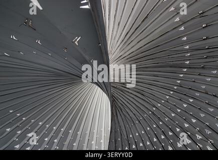 Chongqing, China - 8 Jun 2026 - The composition is dominated by a sweeping vortex of metallic, monochromatic ribs that converge and twist with the ele Stock Photo