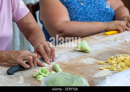 Close up shot of a woman making Orecchiette pasta on a street in Bari, Italy Stock Photo