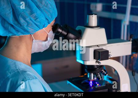 Laboratory Scientist Looking Through Microscope During Medical Research Stock Photo