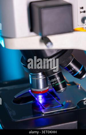 Close Up of Microscope Objective Lens Examining Glass Slide in Laboratory Stock Photo