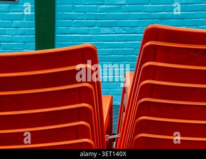 Red plastic stackable chairs on a restaurant patio Stock Photo