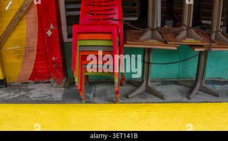 Stacked chairs and tables secured by a metal chain Stock Photo