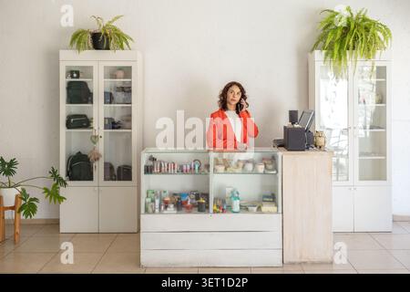 High angle view of a beauty salon owner typing on a computer keyboard while managing reception and administrative tasks. Stock Photo
