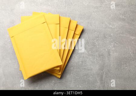 Stack of yellow envelopes on grey table, top view. Space for text Stock Photo