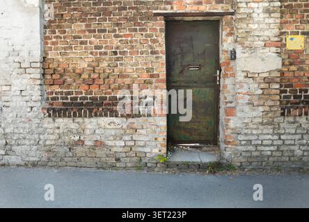 Old rusty metal door in a brick wall Stock Photo