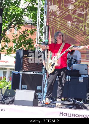 June 20, 2026, Saint Petersburg, Russia. Youth Day celebrations are underway in Malinovka Park in Saint Petersburg. A rock musician in a red T-shirt g Stock Photo