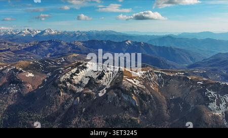 Snow capped mountains under blue sky in spring Stock Photo