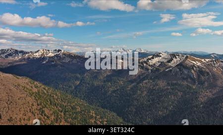 Snow capped mountains under blue sky in spring Stock Photo