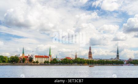 Timeless Riga panorama. Wide view of Riga Old Town skyline stretching along Daugava River under dramatic summer cloudscape, Latvia. Stock Photo
