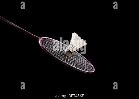 Badminton racket and shuttlecock on black background representing sport and competition Stock Photo