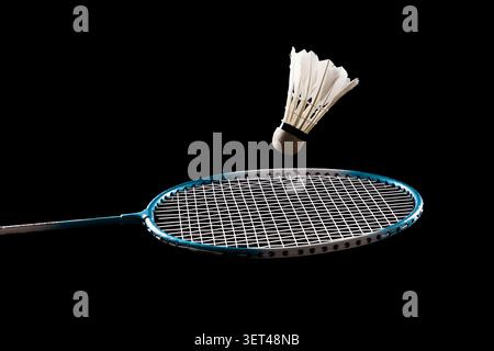 Badminton racket and shuttlecock on black background representing sport and competition Stock Photo