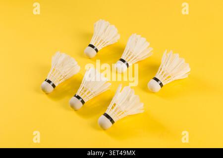 Badminton shuttlecocks lying on a bright yellow surface ready for play Stock Photo