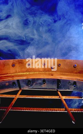 Industrial metal construction, rusty, blue fog as background, rusty, lying on a rusty grid, old dirty engine parts of cars or trucks photographed as s Stock Photo