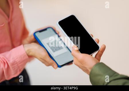 Two Individuals Exchanging Qr Code On Smartphones, Indoor Setting, Unrecognizable Stock Photo