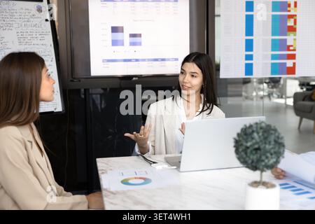 Young businesswoman presenting data at team meeting Stock Photo