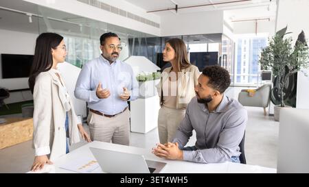 Group of professionals engaged in discussion in modern coworking office Stock Photo