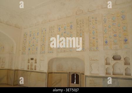 Elaborate decorative wall panels with blue and yellow floral and vase motifs inside the historic Amber Fort in Jaipur, India. Stock Photo