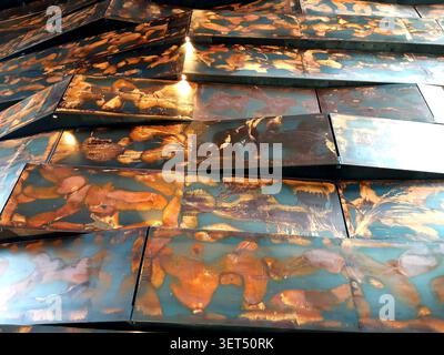 Close-up abstract pattern of overlapping weathered, rusted metal panel cladding on the exterior facade of the Titanic Belfast museum building. Stock Photo