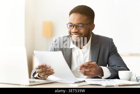 Handsome african american entrepreneur working with documents in office Stock Photo