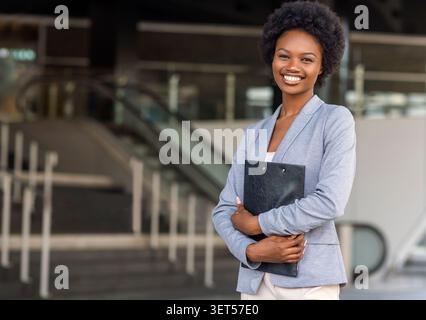 Female African American job seeker keeping a folder with CV Stock Photo