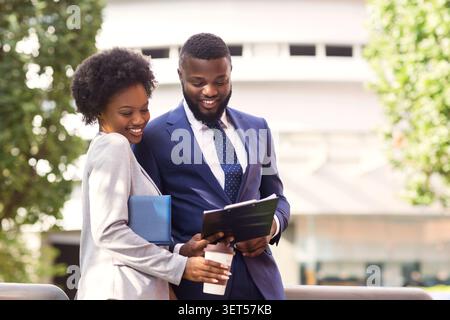 Two african american colleagues discussing new project details outdoors Stock Photo