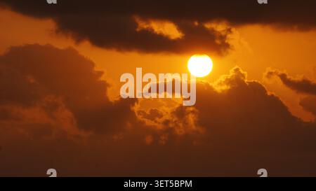 Golden sunset shining through dramatic clouds in the evening sky. Stock Photo