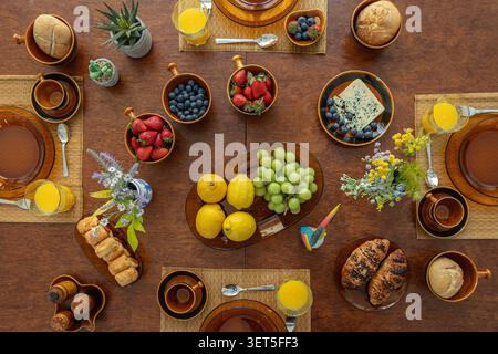 Top view of elegant brunch table with fresh fruit, pastries and orange juice Stock Photo