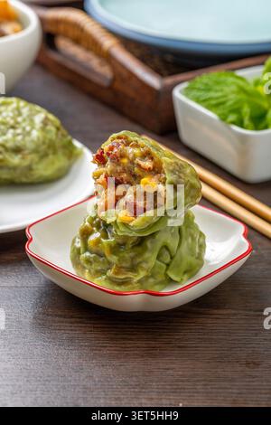 Sliced steamed sticky grain bun stacked on a small white plate with chopsticks background Stock Photo