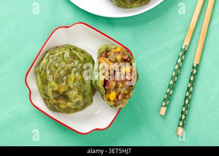 Sliced steamed sticky grain bun stacked on a small white plate with chopsticks background Stock Photo