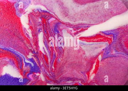 Abstract background showing vibrant fluid art with swirling pink, purple, red, and white paint Stock Photo