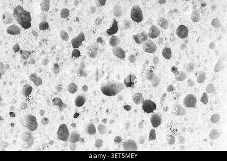 Macro, closeup of white foam sponge texture with porous, spongy and bubbly surface pattern suitable for abstract background design. Foamed polyurethan Stock Photo