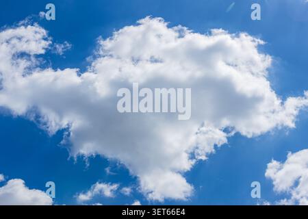 Large white cumulus cloud in a deep blue summer sky Stock Photo