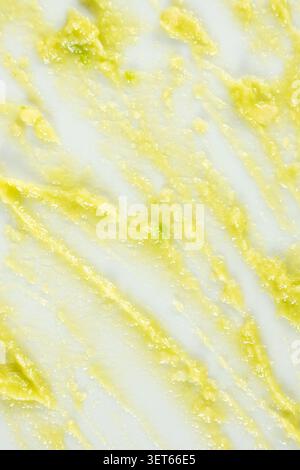 Top view of organic cosmetic avocado mask texture strokes on white background. Stock Photo