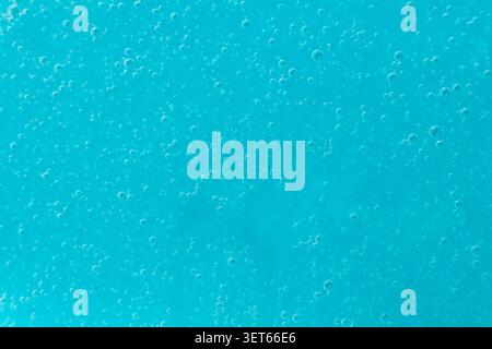 Abstract full frame background of blue liquid soap texture with micro bubbles. Stock Photo