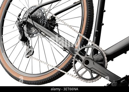 Close-up of a gravel bike. Cassette, chain, crankset and tan wall tire against white background. Stock Photo