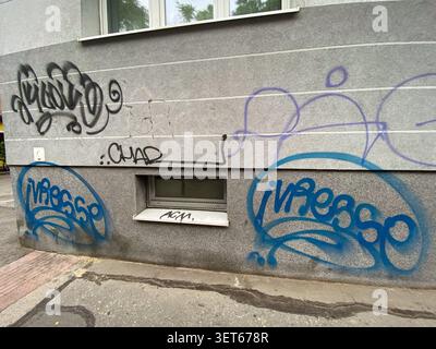 Colorful graffiti and tags painted on the concrete wall of a residential building. June 5, 2026, Bratislava, Slovakia Stock Photo