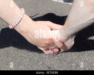 Kyiv, Ukraine - Jun 21, 2026: Two participants are seen holding hands while marching for LGBTQ rights and civil partnership legislation during the Equality March in Kyiv Ukraine. Stock Photo