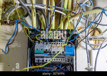Utrecht, Netherlands - June 01, 2026: A close-up view of an old and disorganized home electrical panel with tangled colorful wires and vintage circuit Stock Photo