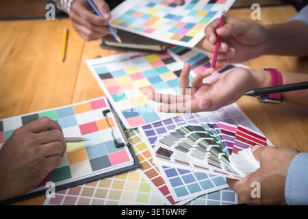 Interior designer chooses a color chart for home design. Graphic designers working on color chart at modern office. Stock Photo
