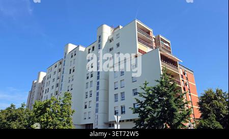 A detailed low angle view capturing the unique geometric balconies, vertical windows, and concrete column staircase of a mid century european Stock Photo