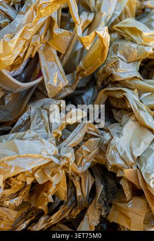 A detailed texture of crumpled plastic packaging film intertwined with strips of adhesive torn tape Stock Photo