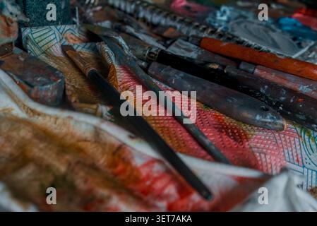 A close up of messy paint covered oil brushes and knifes on paint covered kitchen roll Stock Photo