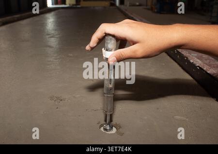 Mechanical wedge anchor bolt being inserted into concrete. Stock Photo