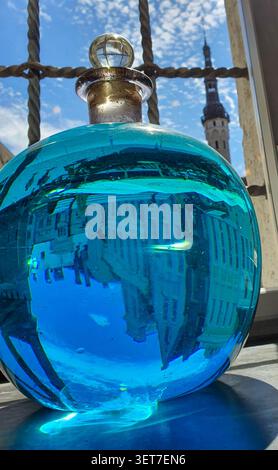 Tallinn, Estonia - 3 July 2020: Close-up of a vintage blue glass potion bottle at the historic Town Hall Pharmacy (Raeapteek), with the reflection of Stock Photo