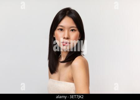 Young Asian Woman Smiling With Natural Makeup, Studio Portrait, Beauty Concept Stock Photo