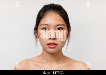 Young Asian Woman With Natural Makeup Showing Calm Expression, Studio Background, Beauty Concept Stock Photo